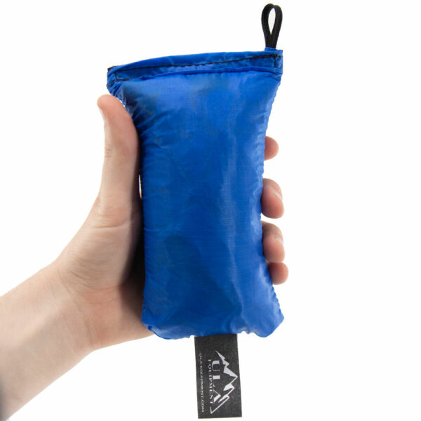 An ultralight ULA Rain Kilt in it's built-in stuff sack in the color Blue. Image shows it fits in a hand.