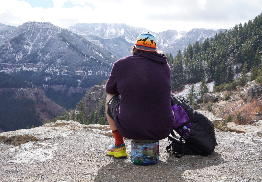 Backpacker sitting on a BearVault. The BearVault also makes an excellent chair. 