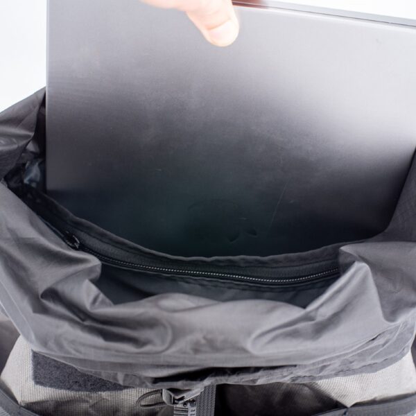 Interior view of ULA Packrat with a laptop being inserted into the laptop sleeve