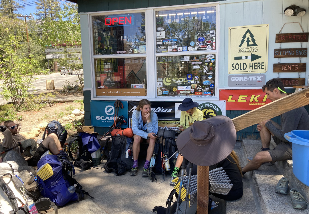 A group of thru-hikers sit outside a store during a respupply