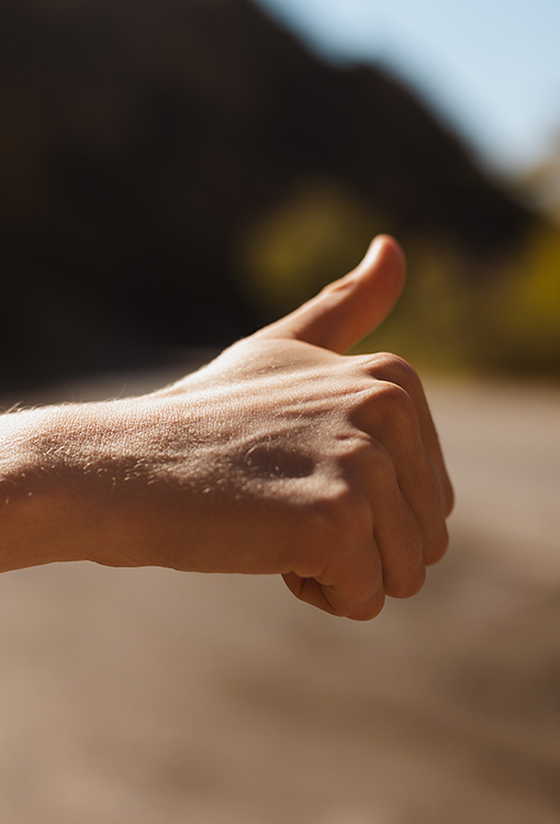 A picture of a woman's closed fist with her thumb up.