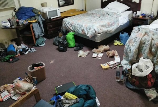 A hotel floor shows backpacks and trash from thru-hikers.