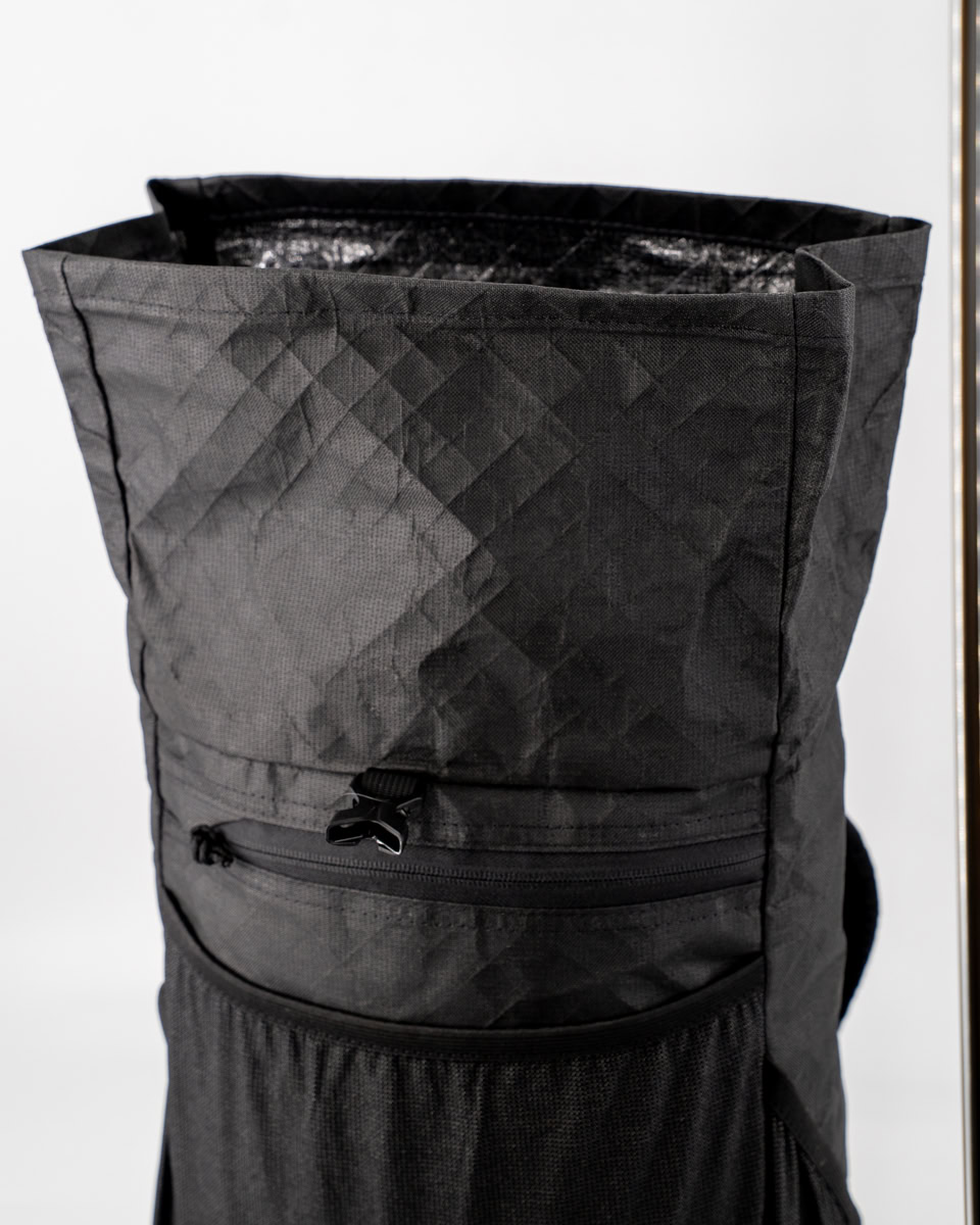 Backpacker puts a Bear Vault Bear Canister into a ULA CDT Backpack