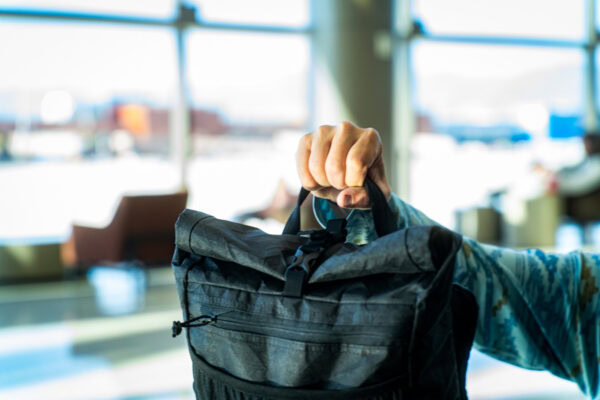 A traveler hols his full ULA Ultra Node up by the padded haul loop.