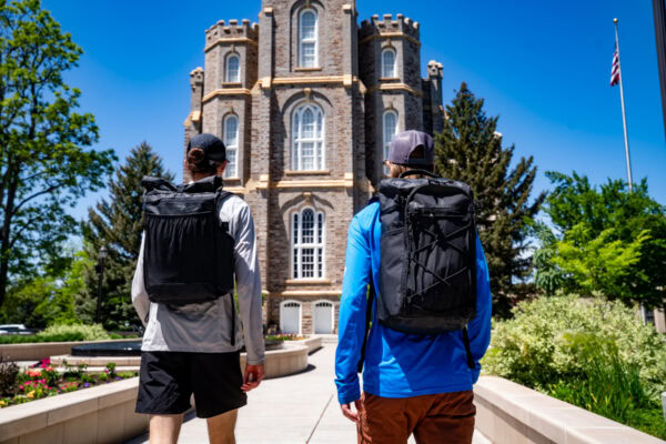 Two urban day hikers wear a ULA Node and ULA Dragonfly while touring a historic building