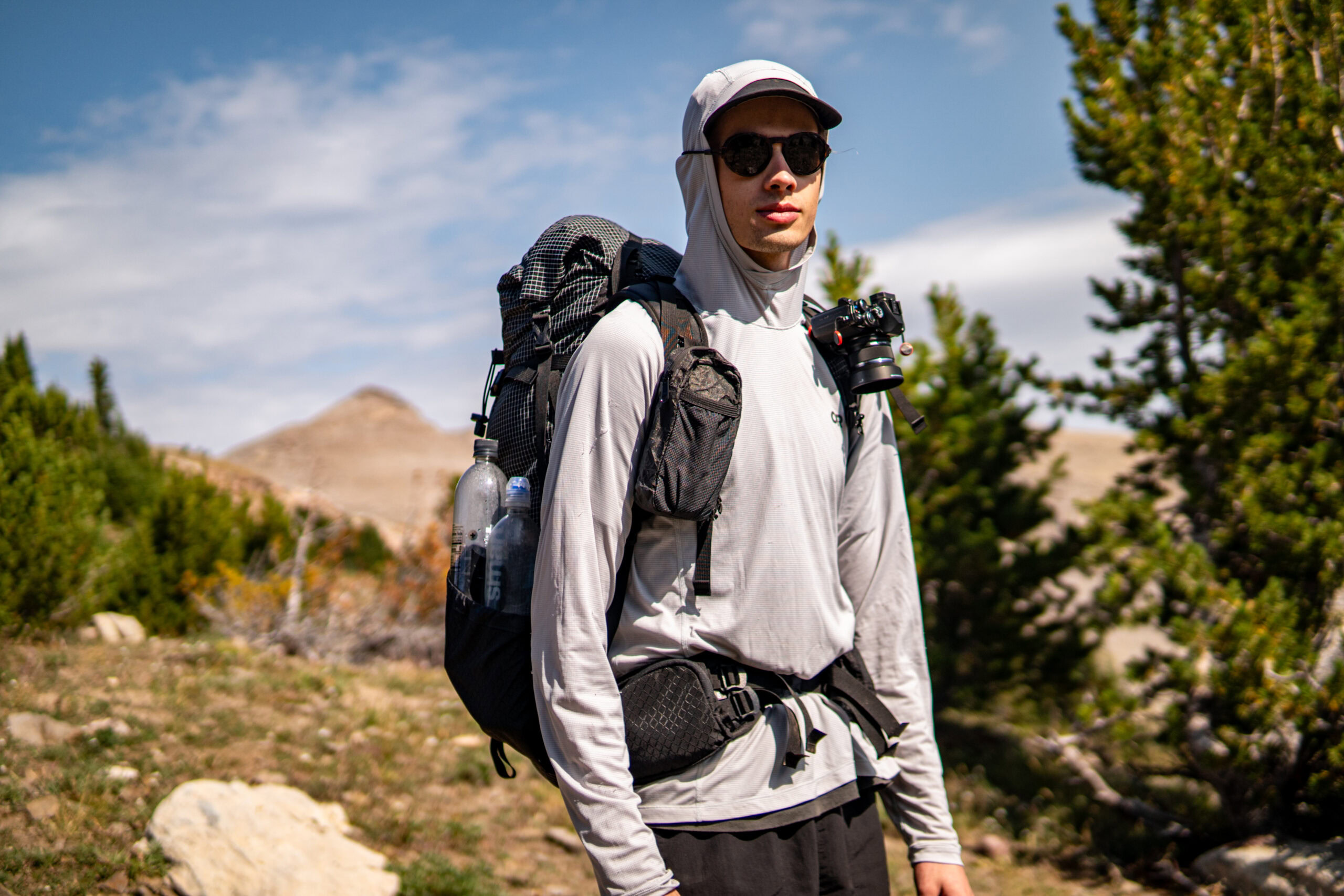 Owen in Montana A man wears a backpack and sunglasses in Montana.