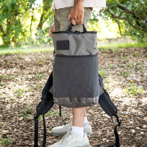 a man holds an ultra packrat by his side.