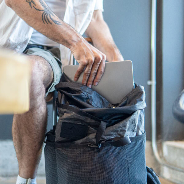 A man pulls a laptop out of his bag