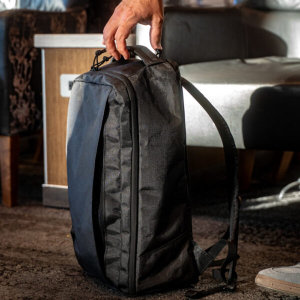 A man grabs the padded haul loop of his Ultra Cicada Daypack