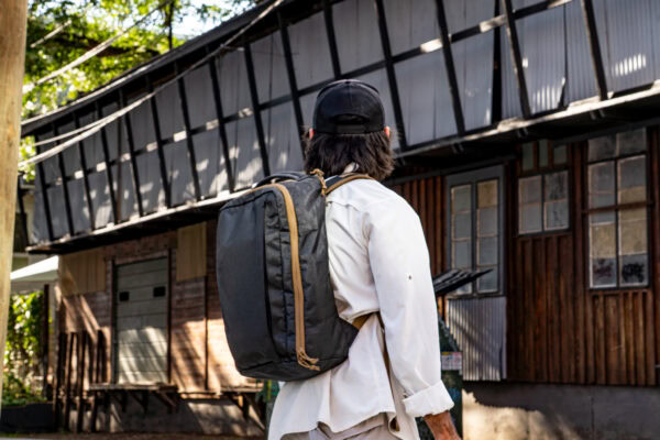 A man wearing a black and coyote brown backpack
