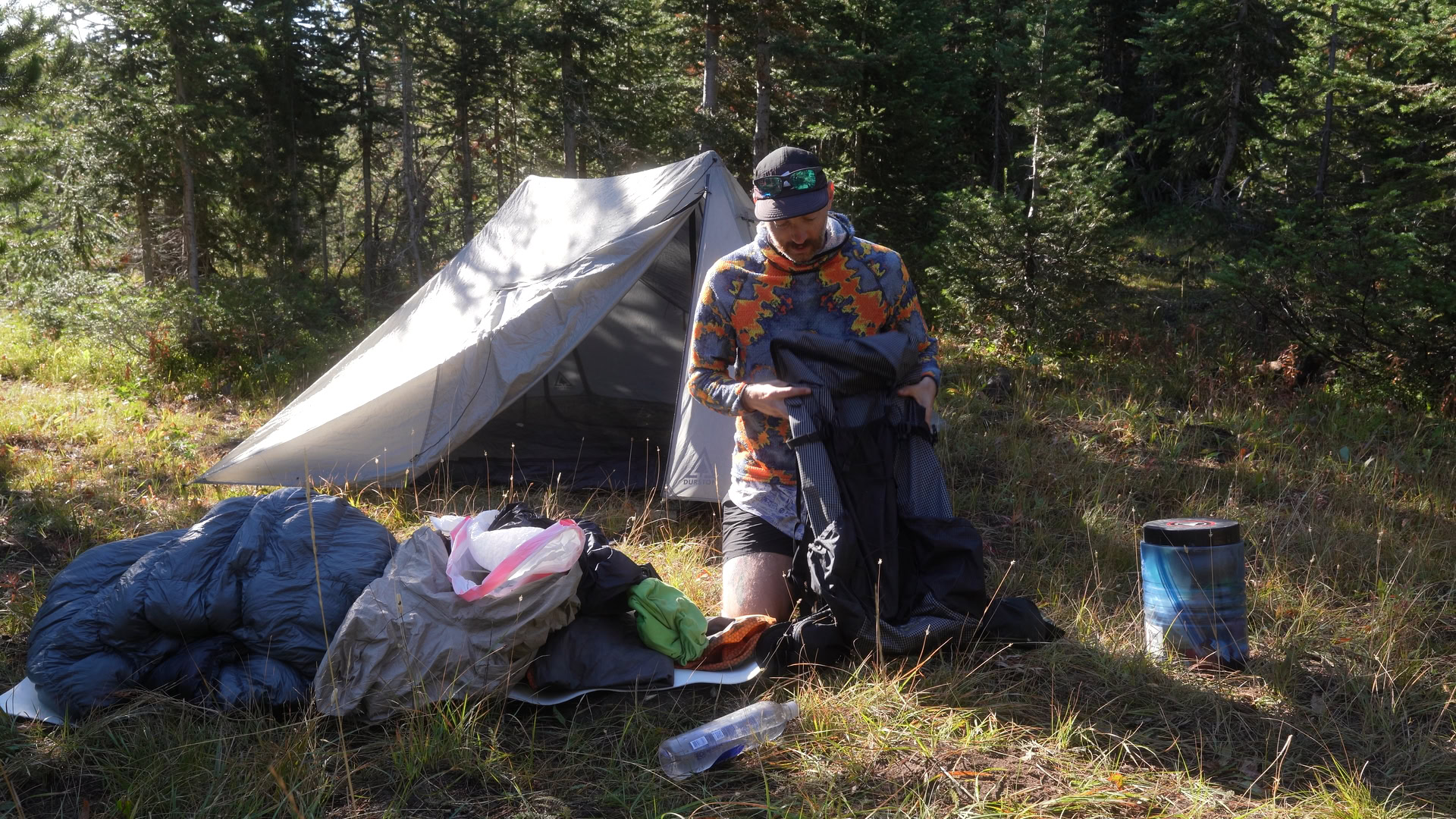 Still 2025-09-11 100425_1.1.1 A man loads his backpack while out on a camping trip.