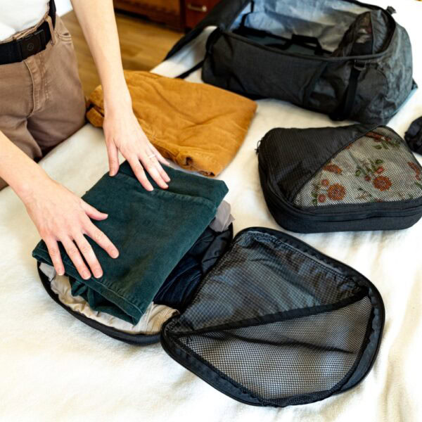 A traveler packs a Conformist Compression Cube.