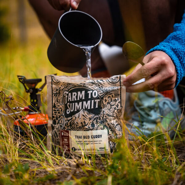 A man pours hot water into a dehydrated food pou