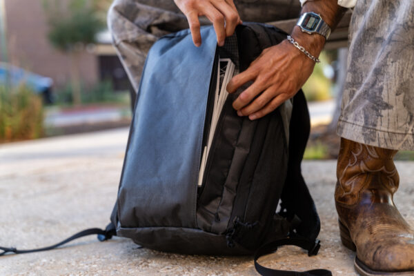 A man with cool cowboy boots removes papers from his Cicada with Pockets