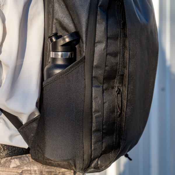 A close up image of the side pocket with a water bottle in it.