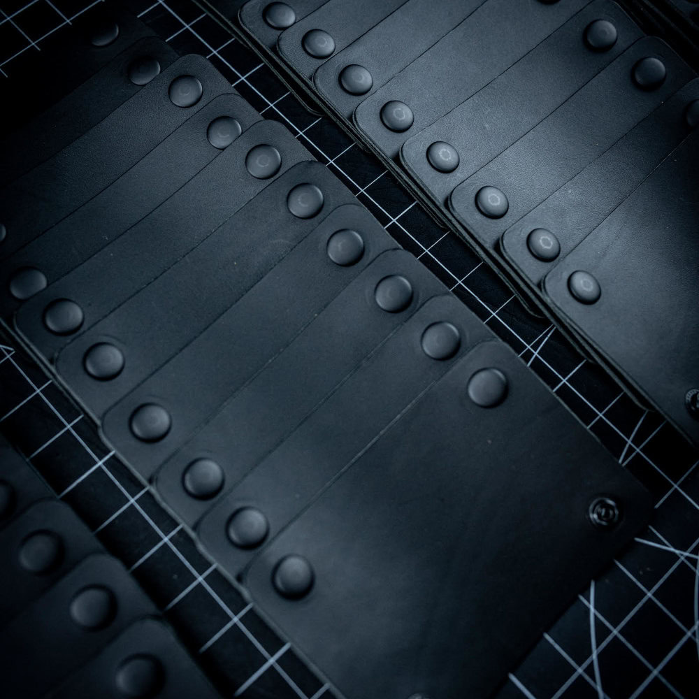 Black leather Dragonfly Grip-Its lined up on a desk