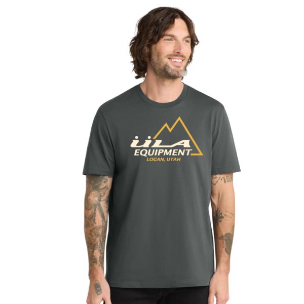 A man wears the NewEra Vintage ULA logo Tshirt in terrain grey with a white and gold (yellow) ULA logo.