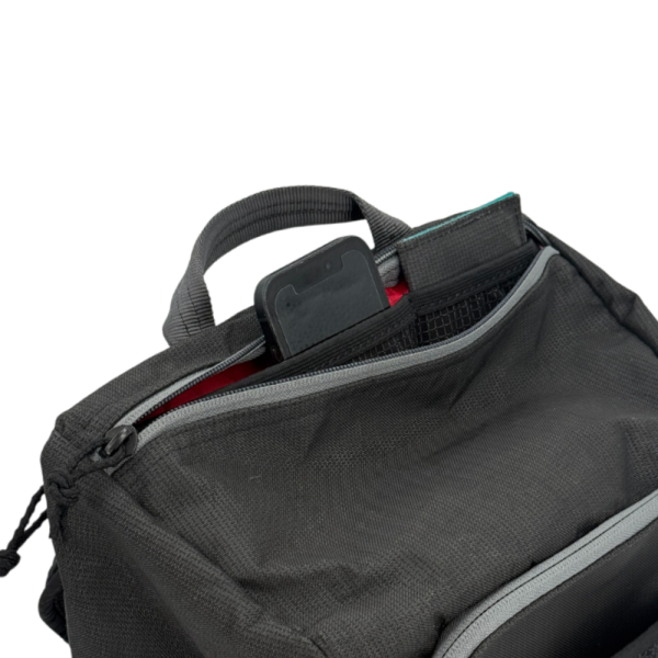 A detail view of the Bespoke 36L Dragonfly 0226 Dia de los Muertos top pocket, showing the phone and wallet sleeve