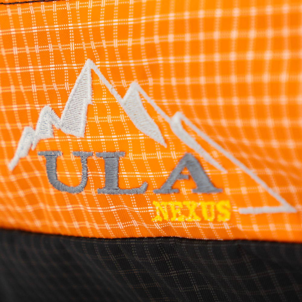 Backpacker on the trail with a ULA Circuit with Bottom Straps carrying a sleeping pad
